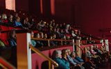 A group of people sitting in an auditorium.