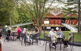 A group of people sitting at tables on an outdoor patio.